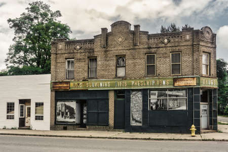 Front of an aged and worn exterior of abandoned store selling toys, souvenirs, gifts, and drugs.
