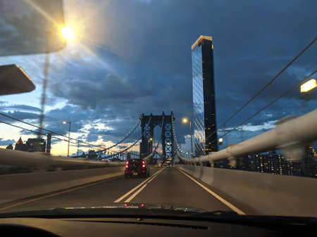 driving during sunset through Manhattan Bridge in New York City