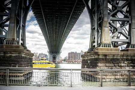 View of Williamsburg Bridge beneath. Looking at Brooklyn side and a NYC water taxiのeditorial素材
