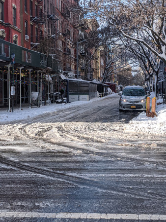 New York, USA - December 12: East Village street in Manhattan covered with pile of snow. Empty winter road with melting snowのeditorial素材