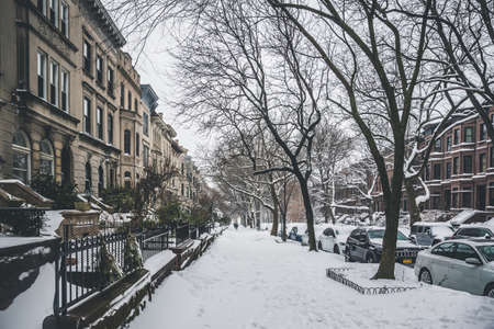 Winter scene with snow covered cars parked along streets in Brooklyn, NY. Brownstones in winter seasonのeditorial素材