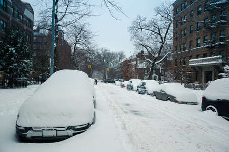 Winter scene with snow covered cars parked along streets in Brooklyn, NY. Brownstones in winter seasonの写真素材