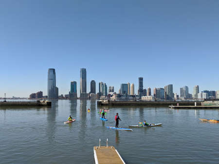 New York, USA - March 21 2021: A group of people on kayaks and paddle boards on Hudson River with a view of New Jerseyのeditorial素材