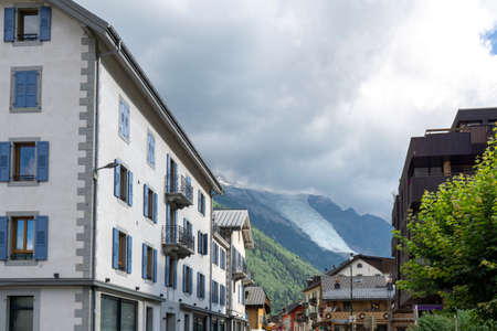 Chamonix-Mont-Blanc, Haute Savoie, France - August 25 2021: View on a glacier in the Alps seen from the Chamonix city. Street with buildings.のeditorial素材