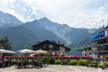 Courmayeur, Italy - August 24 2021: Restaurant or cafe with an outdoor space in northern Italy. Umbrellas, parasols with table and chairs and mountain view on Alpsのeditorial素材