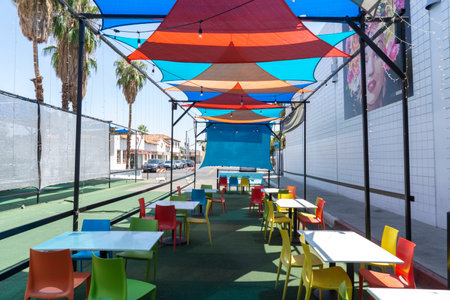 San Diego, California, USA - August 8, 2021: Colorful fabric shades on outdoor restaurant with chairs and tables. Empty seats outsideのeditorial素材