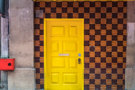 Facade of a building with yellow doors and checked pattern tiles wall in Portugalの写真素材