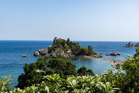View of Isola Bella island in Taormina, Sicily, Beach with tourists surrounded by the Seaの写真素材