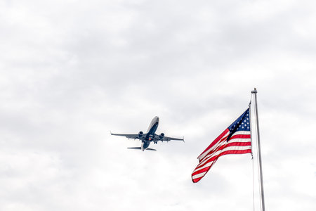 Airplane from Delta airlines flying in the sky against the background of the american flagのeditorial素材