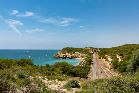 View of Sitges from distance. Train tracks. Landscape of coast, sea and mountainsの写真素材