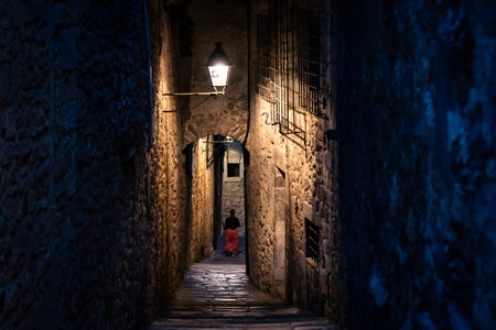 Narrow alleyway with stone walls and steps at the evening or nightの写真素材