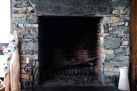 Large, stacked stone wall next to indoor fireplace with ashes insideの写真素材