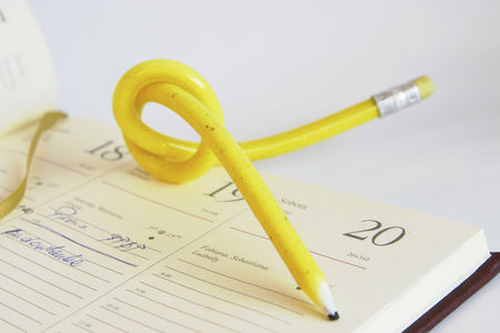 yellow, twisted pencil on a diaryの写真素材