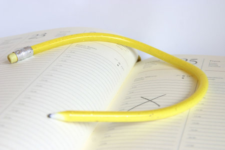 yellow, twisted pencil on a diaryの写真素材