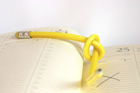yellow, twisted pencil on a diaryの写真素材