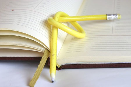 yellow, twisted pencil on a diaryの写真素材