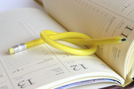 yellow, twisted pencil on a diaryの写真素材
