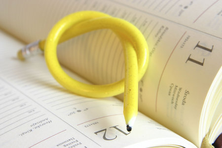 yellow, twisted pencil on a diaryの写真素材