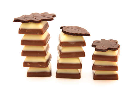 three dark and white chocolates piles isolated on whiteの写真素材