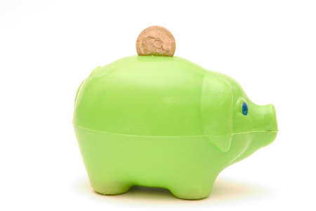 Green piggybank with pound coin isolated on whiteの写真素材