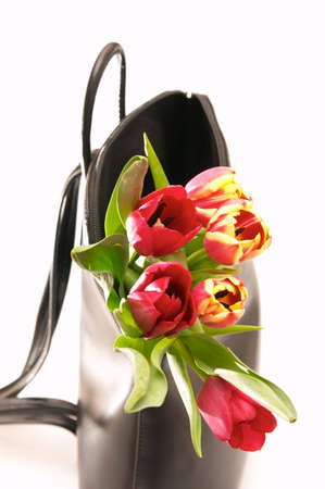 beautiful red spring tulips in black handbag の写真素材
