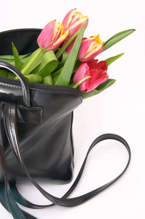 beautiful red spring tulips in black handbag の写真素材