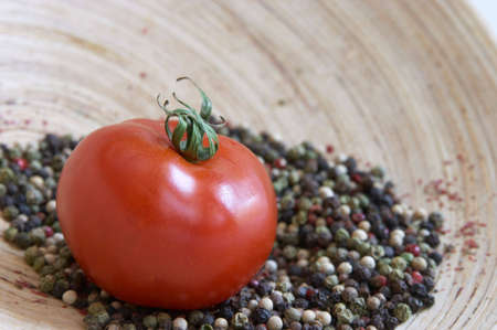 red tomato and pepper on a wooden plateの写真素材