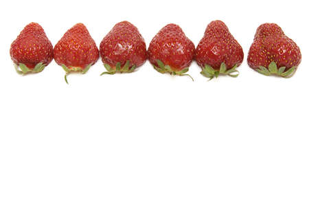 fresh strawberries with hulls in a row, copy space, isolated on whiteの写真素材