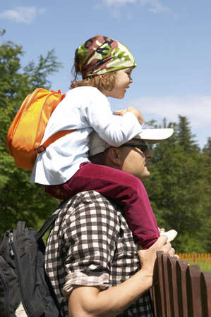 little, cute girl on her father arms, blue sky in backgroundの写真素材