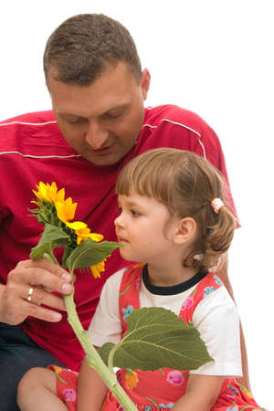 father and little girl smelling yellow sunflowerの写真素材