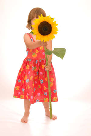 adorable little girl holding big yellow sunflowerの写真素材