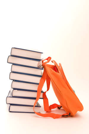 pile of books and orange backpack isolated on whiteの写真素材