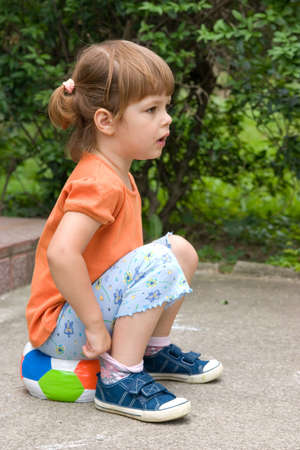 little, cute girl with colorful football, outdoorsの写真素材