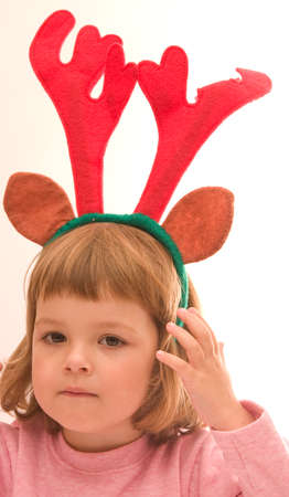 little, cute girl wearing reindeer horns, isolated on whiteの写真素材