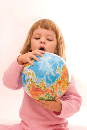 little girl holding globe isolated on whiteの写真素材