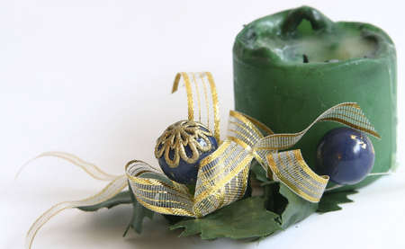 green Christmas candle decorated with mistletoe and golden ribbonの写真素材