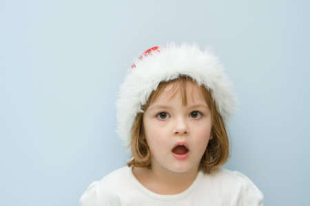 portrait of little, cute girl wearing Santa's hat