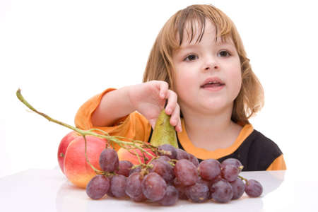 little smiling girl and fruits isolated on whiteの写真素材