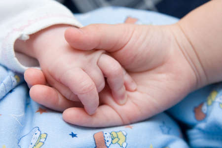 kid hand holding little, newborn's hand