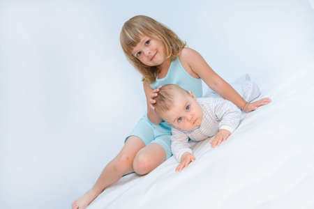 little brother and sister playing together, on whiteの写真素材