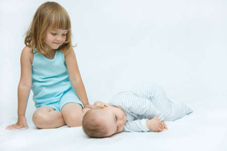 little brother and sister playing together, on whiteの写真素材