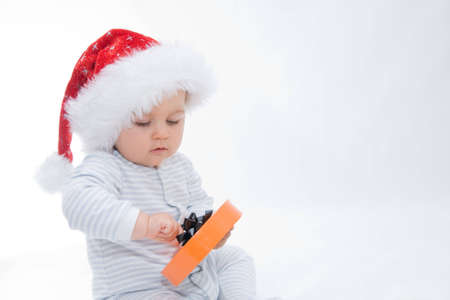 little, cute baby boy wearing Christmas hat, on whiteの写真素材