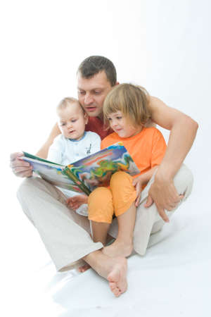 young father reading fairy tale to childrenの写真素材