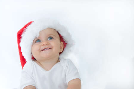 little, cute baby boy wearing Christmas hat, on white
