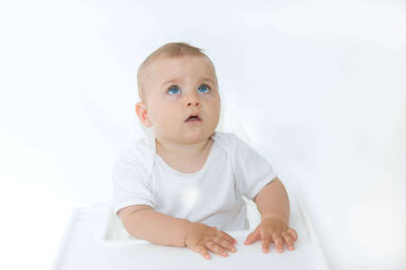little, cute baby boy looking up, on white