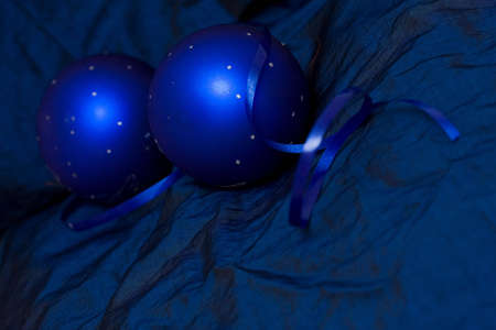 two Christmas baubles on blue backgroundの写真素材