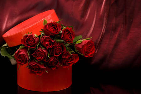 gift box with bunch of red roses on purple backgroundの写真素材