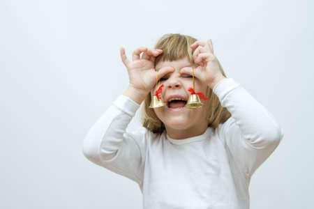 little, cute girl playing with golden Christmas bellsの写真素材