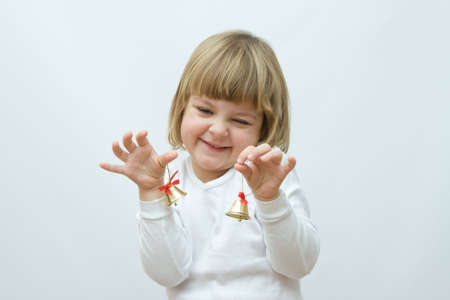 little, cute girl playing with golden Christmas bellsの写真素材