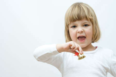 little, cute girl playing with golden Christmas bellsの写真素材